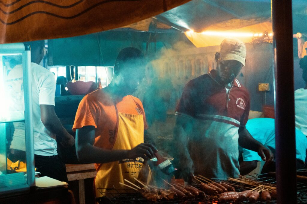 Street vendors grill meat in Accra, Ghana. Capturing the vibrant food scene.